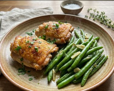 Saftige Hähnchenschenkel mit Knoblauchbohnen in Butter